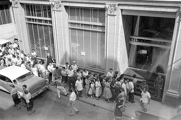 A line of Cubans extending around the corner wait their turn at the Godoy-Sayan Bank in Havana  April 5, 1958 which bore the brunt of heavy withdrawals. Many depositors fearing for the safety of their savings with the treat of civil war hanging over the island republic are withdrawing their savings. 