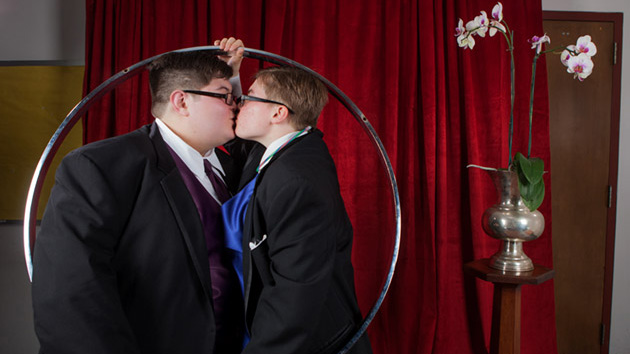 Two people kissing inside a metal hoop.