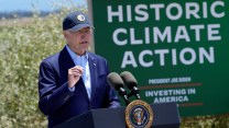 President Joe Biden speaks at the Lucy Evans Baylands Nature Interpretive Center and Preserve, with a sign that says "Historic Climate Action" behind him