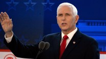 Mike Pence outstretches his right hand during a debate.