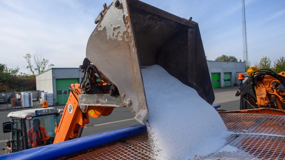 Road salt being poured into a machine of sorts