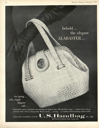 A gloved hand displays a white, alligator leather handbag.