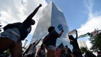 Protestors with signs and raised fists march down a street in downtown Atlanta.