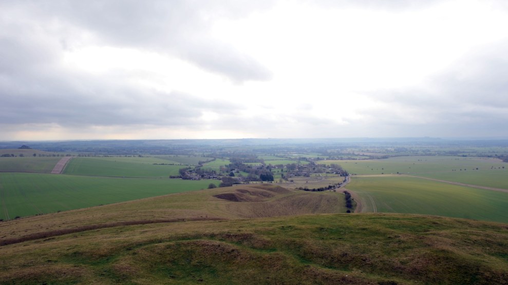 A cloudy sky over brown and green hills.