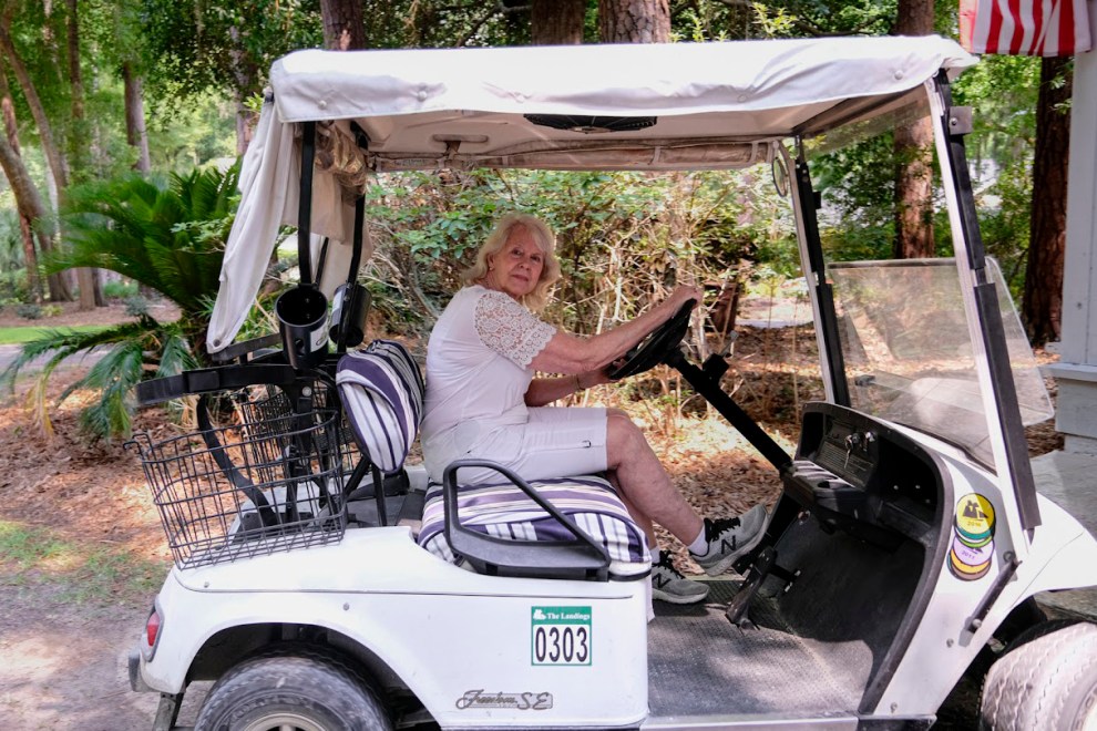 A woman sitting in her golf cart