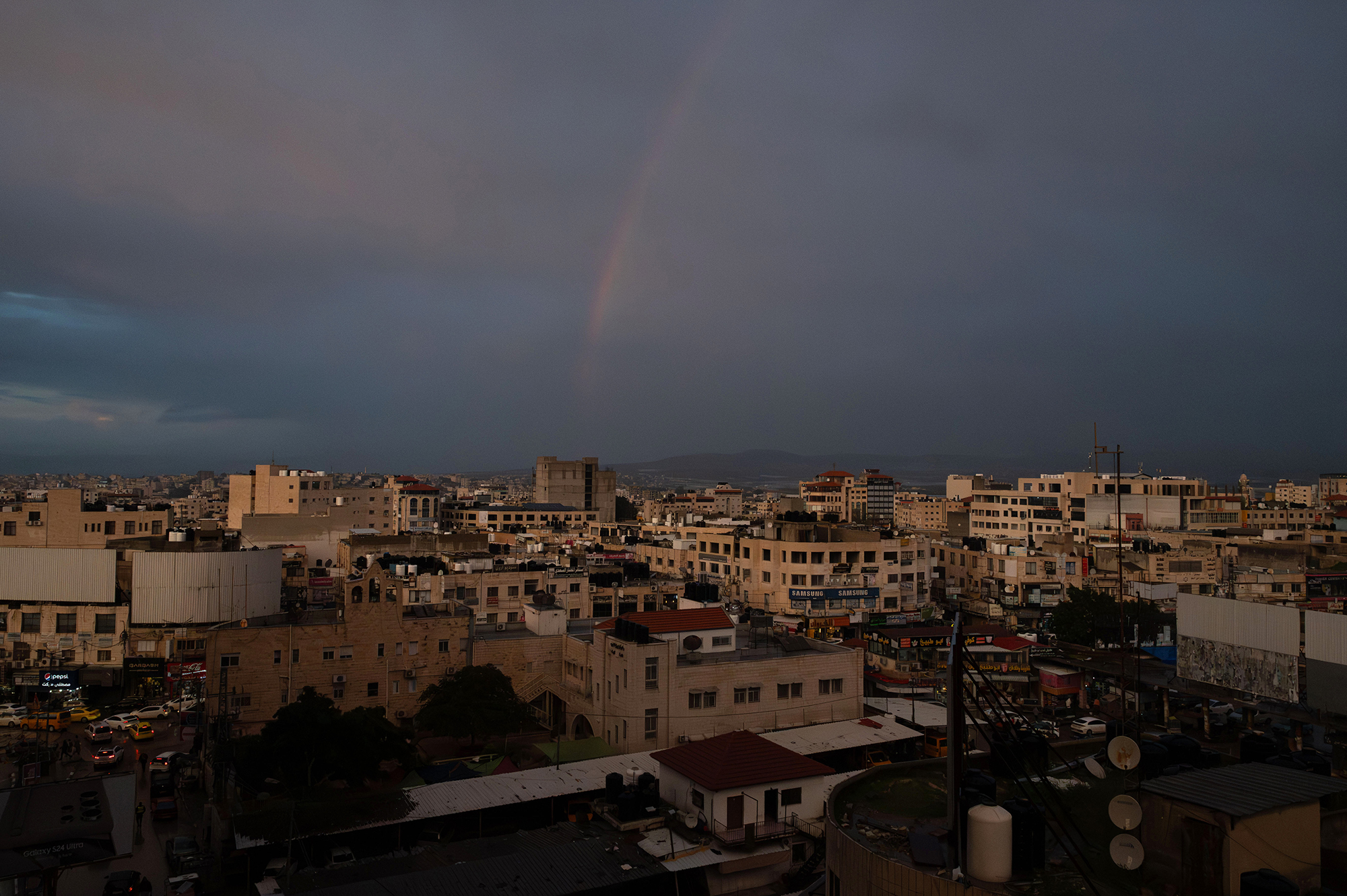 Rainbow over landscape of a city.