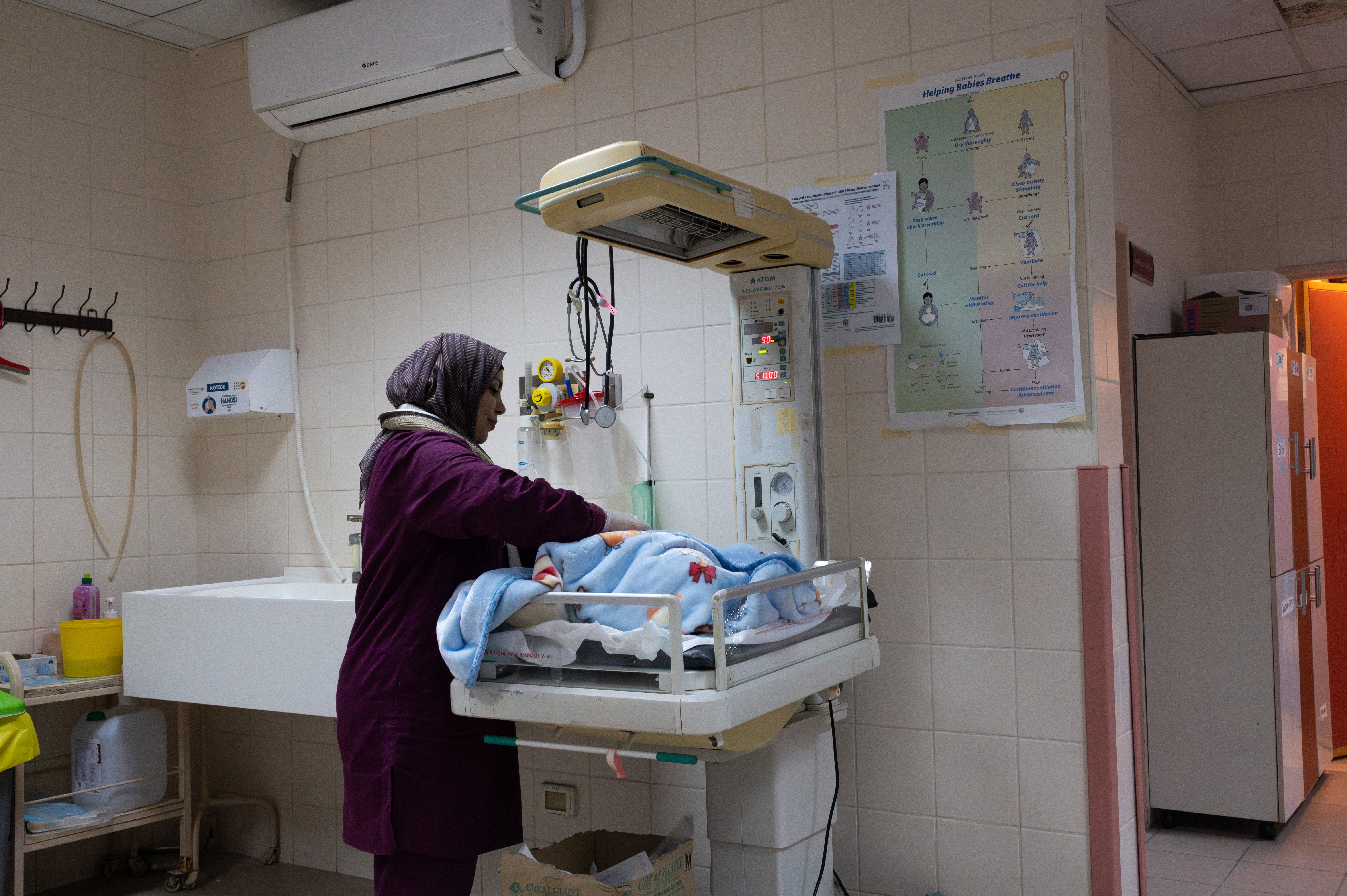 Woman standing over a newborn baby in a hospital room