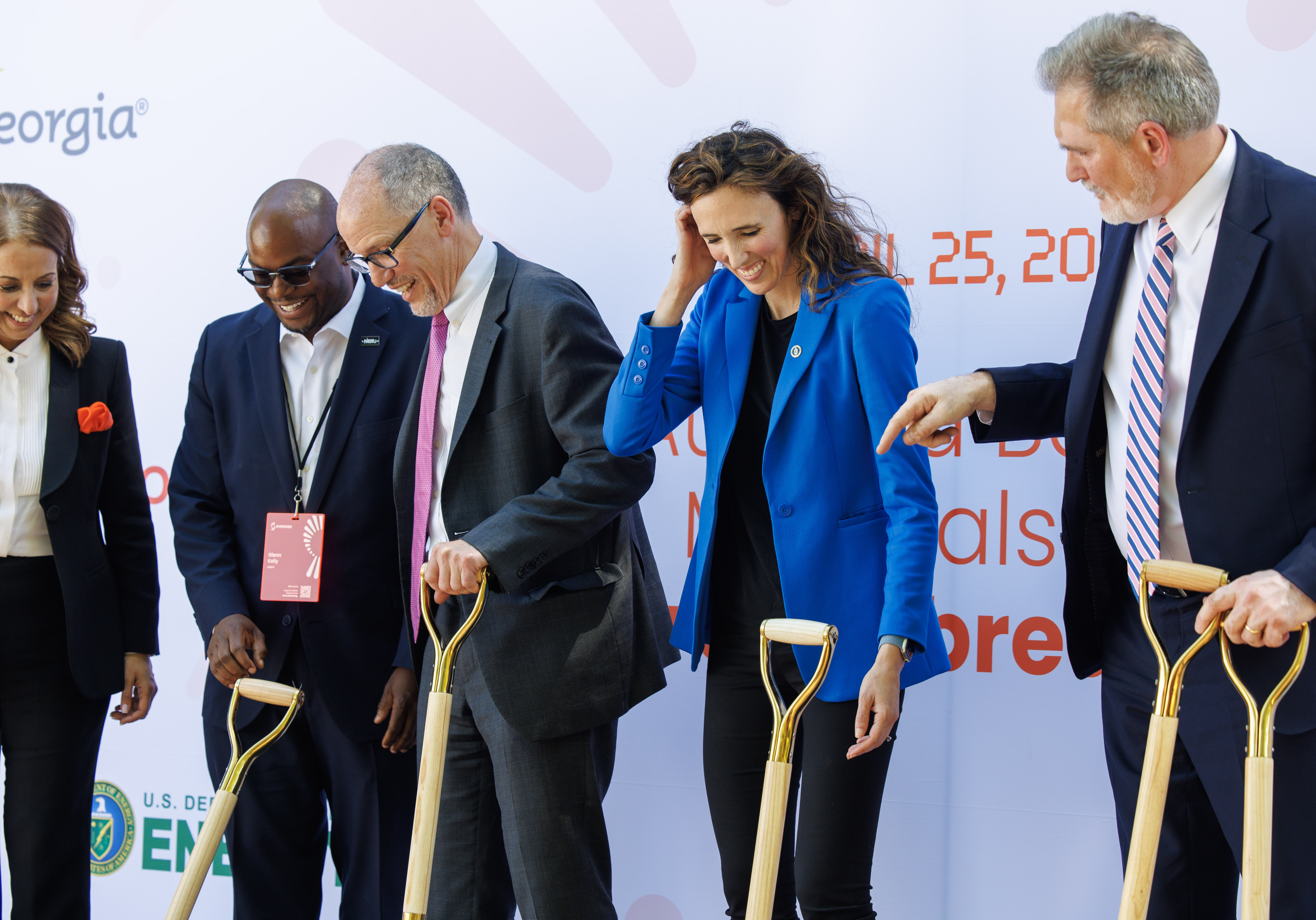 Group of people standing with shovels.