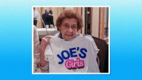 A woman holding up a t-shirt that reads "JOE'S Girls"