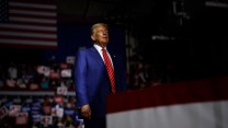 Standing in the shadows, Donald Trump prepares to take the stage during a campaign rally in Pennsylvania.