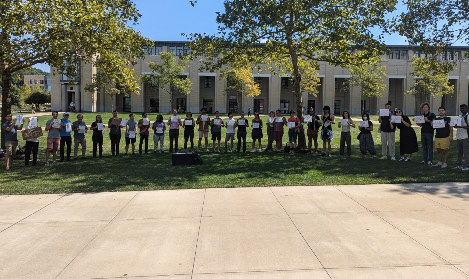 Carnegie Mellon students, professors, and alumni line up on a quadrangle holding signs labeled "1" through "29"