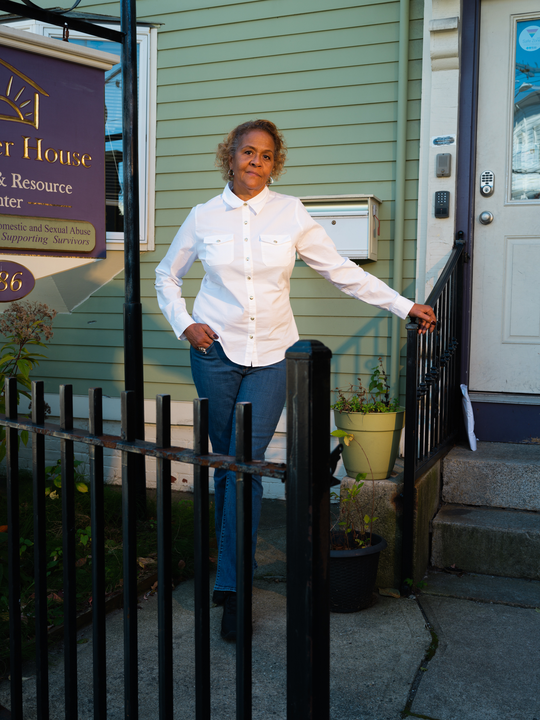 Woman standing in front of a door, holding on to a metal railing.