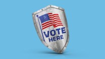 A photo illustration of a realistic shield with the words "VOTE HERE" and an American flag graphic printed on the front