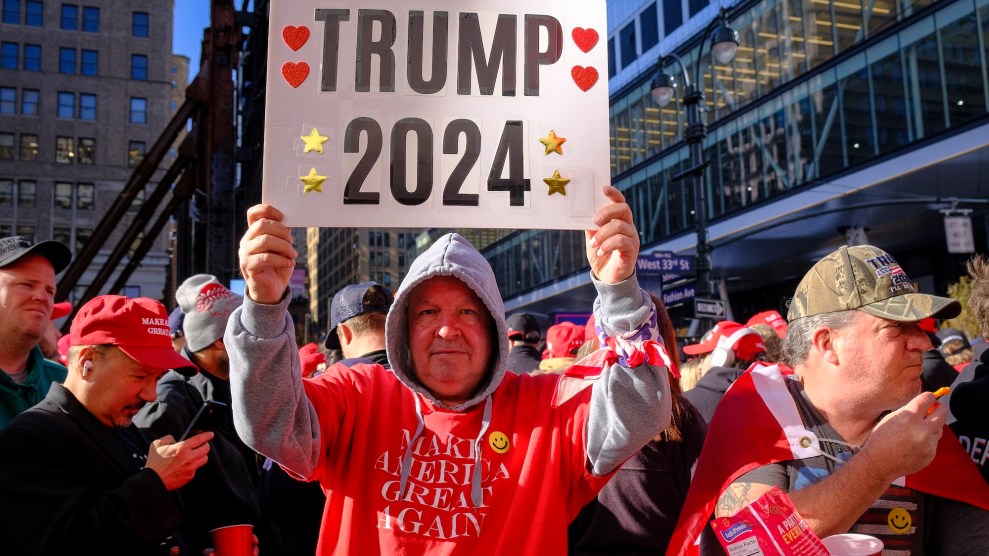 A white man in an orange Make America Great Again t-shirt holds a Trump 2024 placard outside Madison Square Garden.