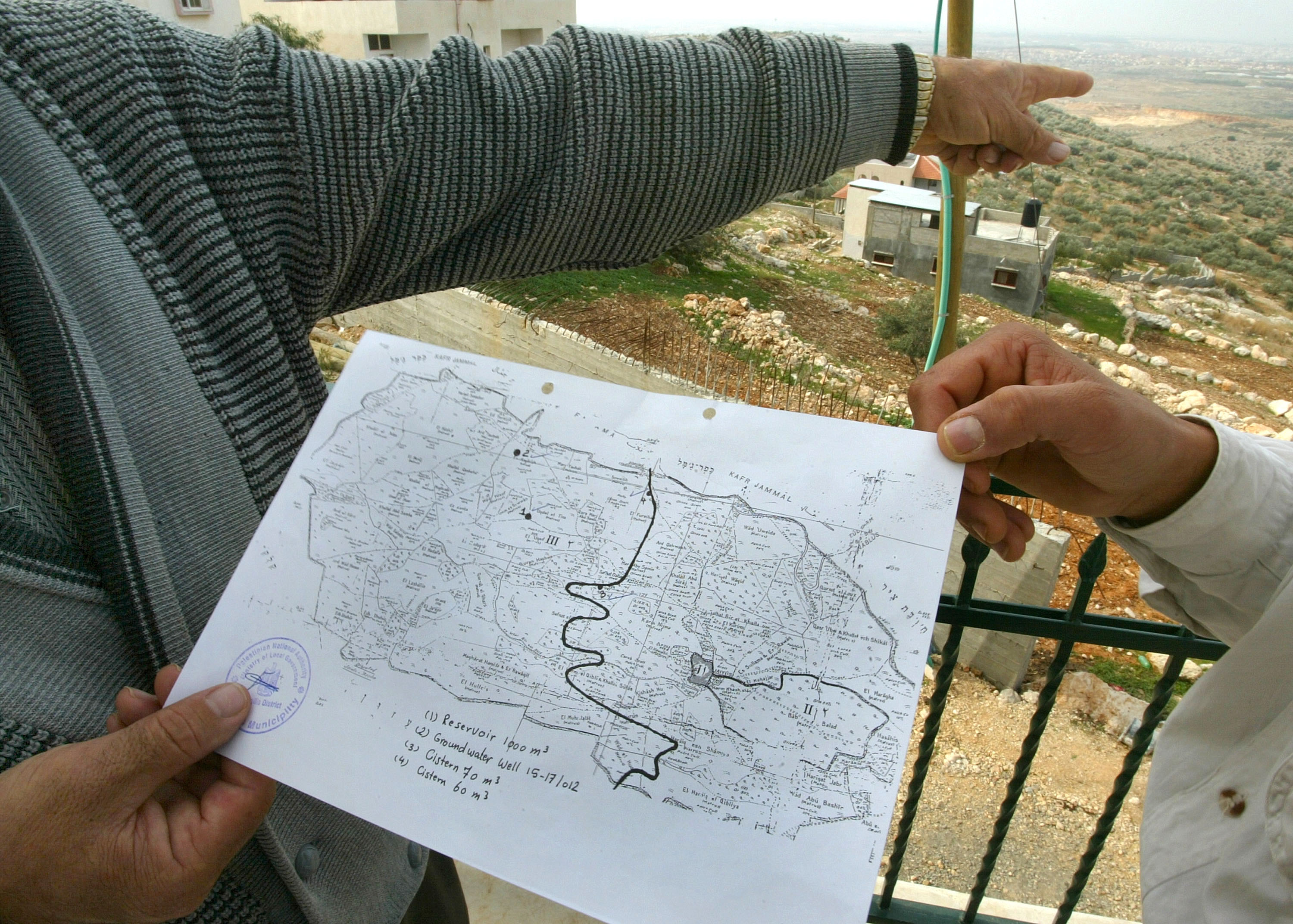 Man holding a map, pointing into the distance.