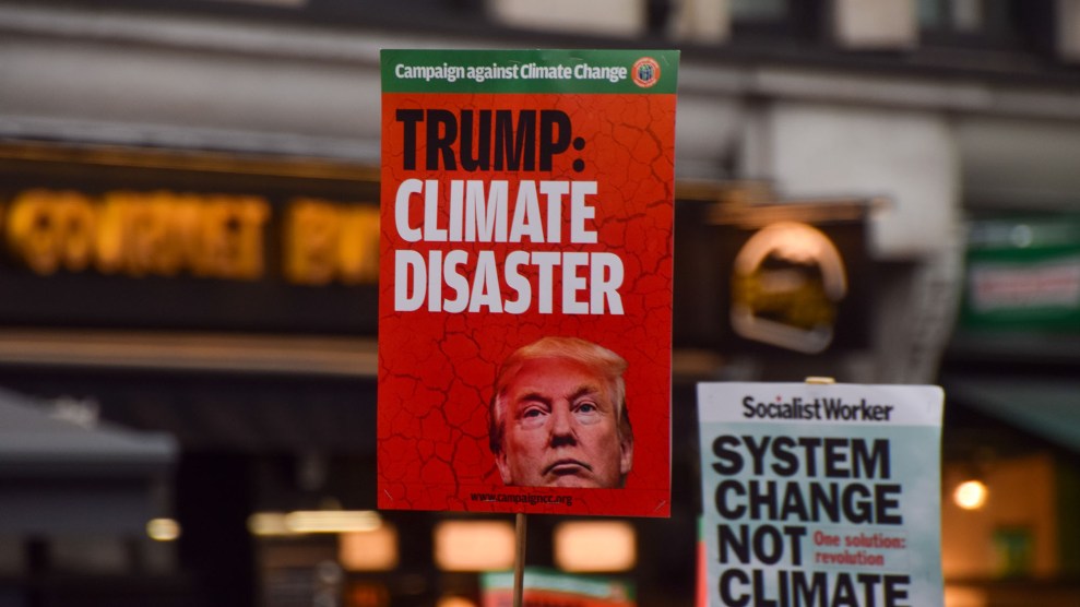 Red sign that says "Trump: Climate disaster" with his face on it.