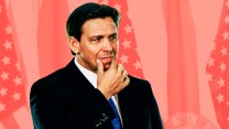 A a photo of Ron DeSantis in suit and tie, as he rubs his chin and looks to our right seemingly with skepticism in his eyes. While DeSantis is in full color, the background, lined with a series of American and Florida flags, is bathed in a red gradient.