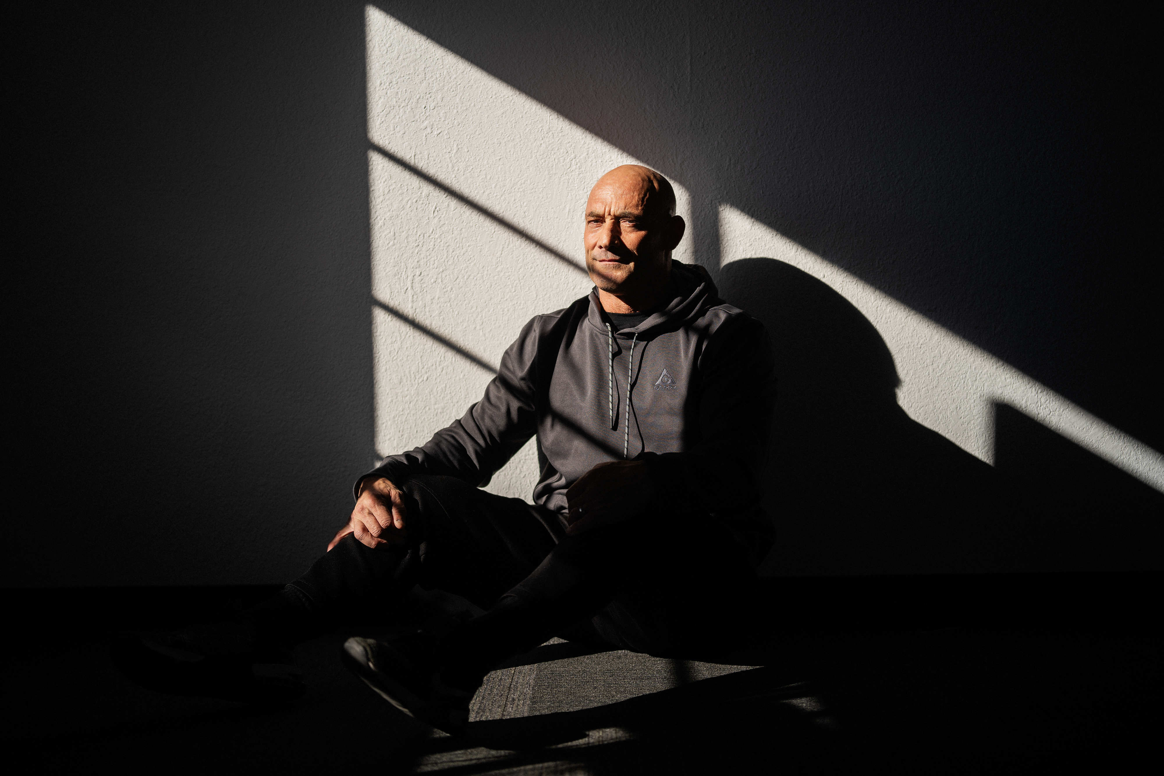 Man sitting in a heavily shadowed room.