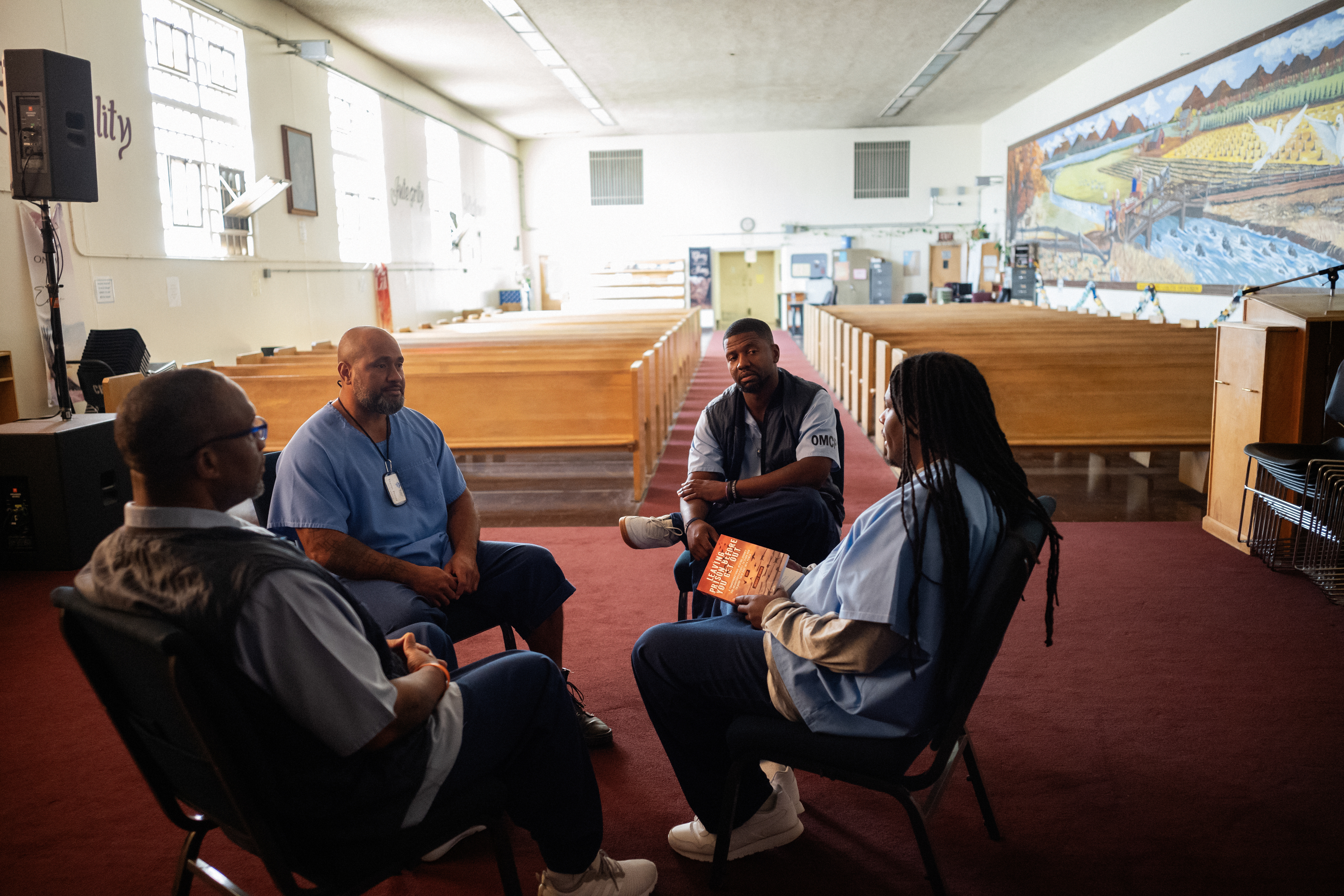 Group of men sitting in a circle, in a chapel.