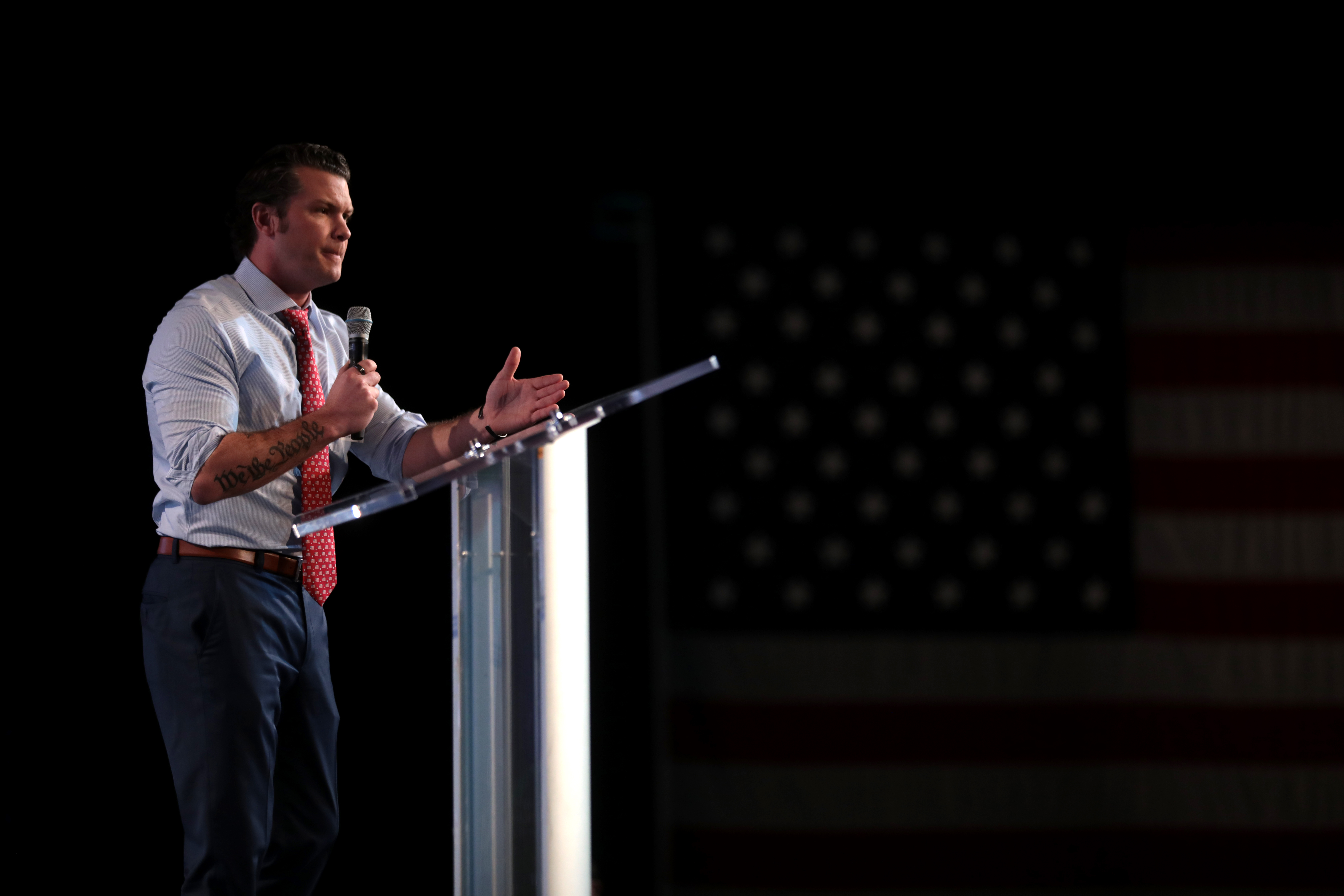 Pete Hegseth stands on a podium.