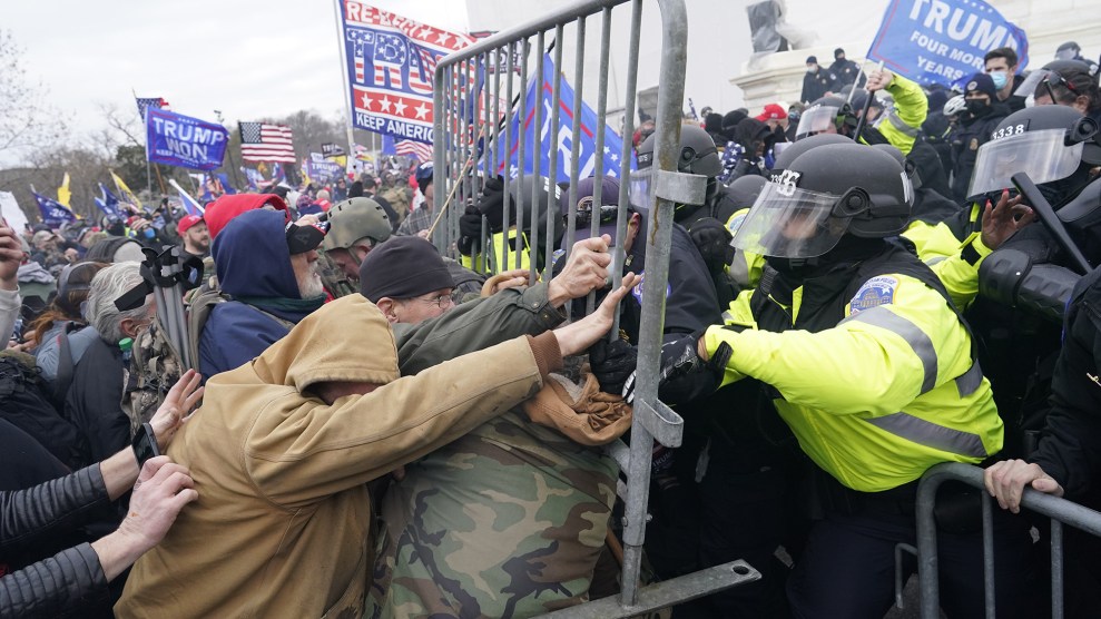 Protesters use metal gates to attack police clad in riot gear.