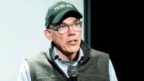 A white man wearing a green hat that says "third act."