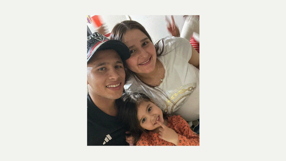 A young Hispanic man, smiling while wearing a black t-shirt and black Guess cap, poses, with heads together, with a young Hispanic female in a white shirt. Their young daughter, placed between them, smiles as she holds the index finger on her left hand up to her lips.