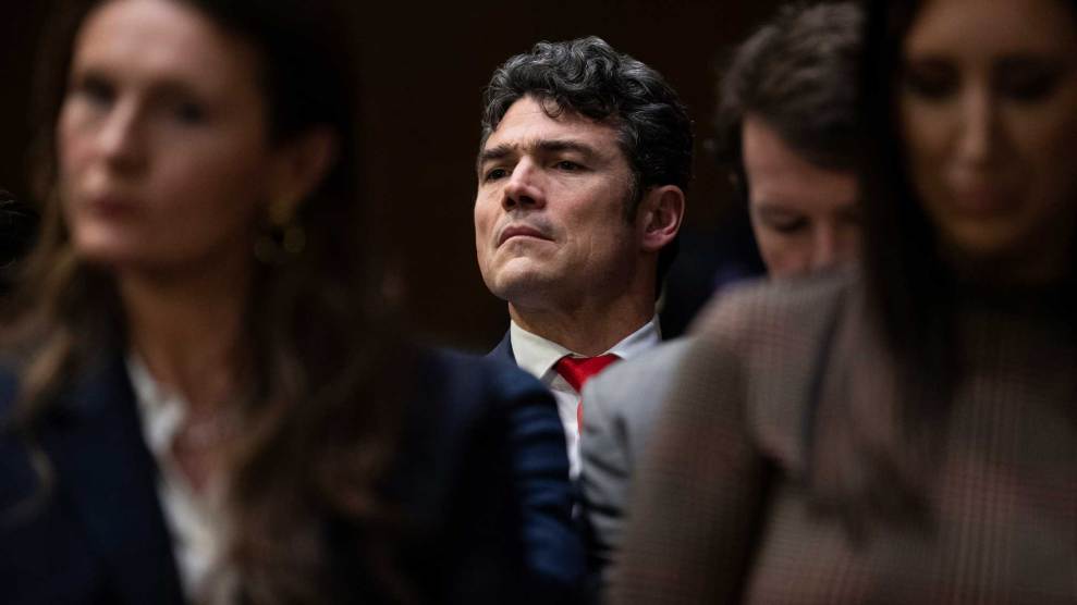 Joe Kent standing in the background of three people.