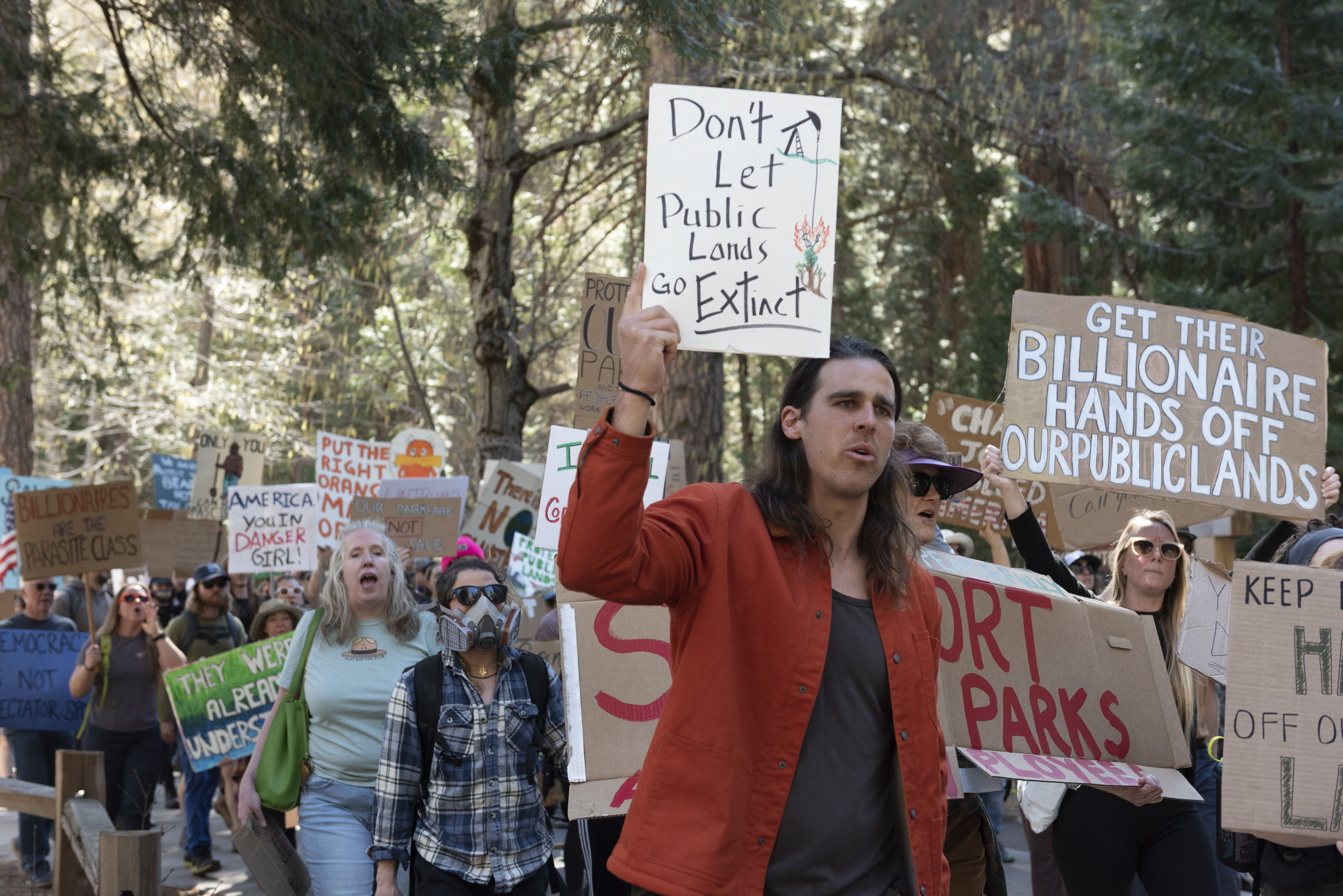 Protester holds a sign that says "Don't let public lands go extinct."