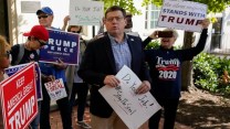 Ed Martin stands among protesters at a "Stop the Steal" rally. He holds a sign that reads, "Do your job! #StopTheSteal"