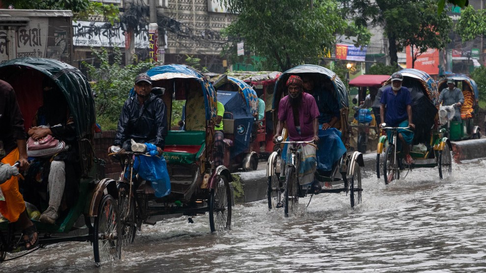 Cyclists pull rickshaws in waterlogged streets.