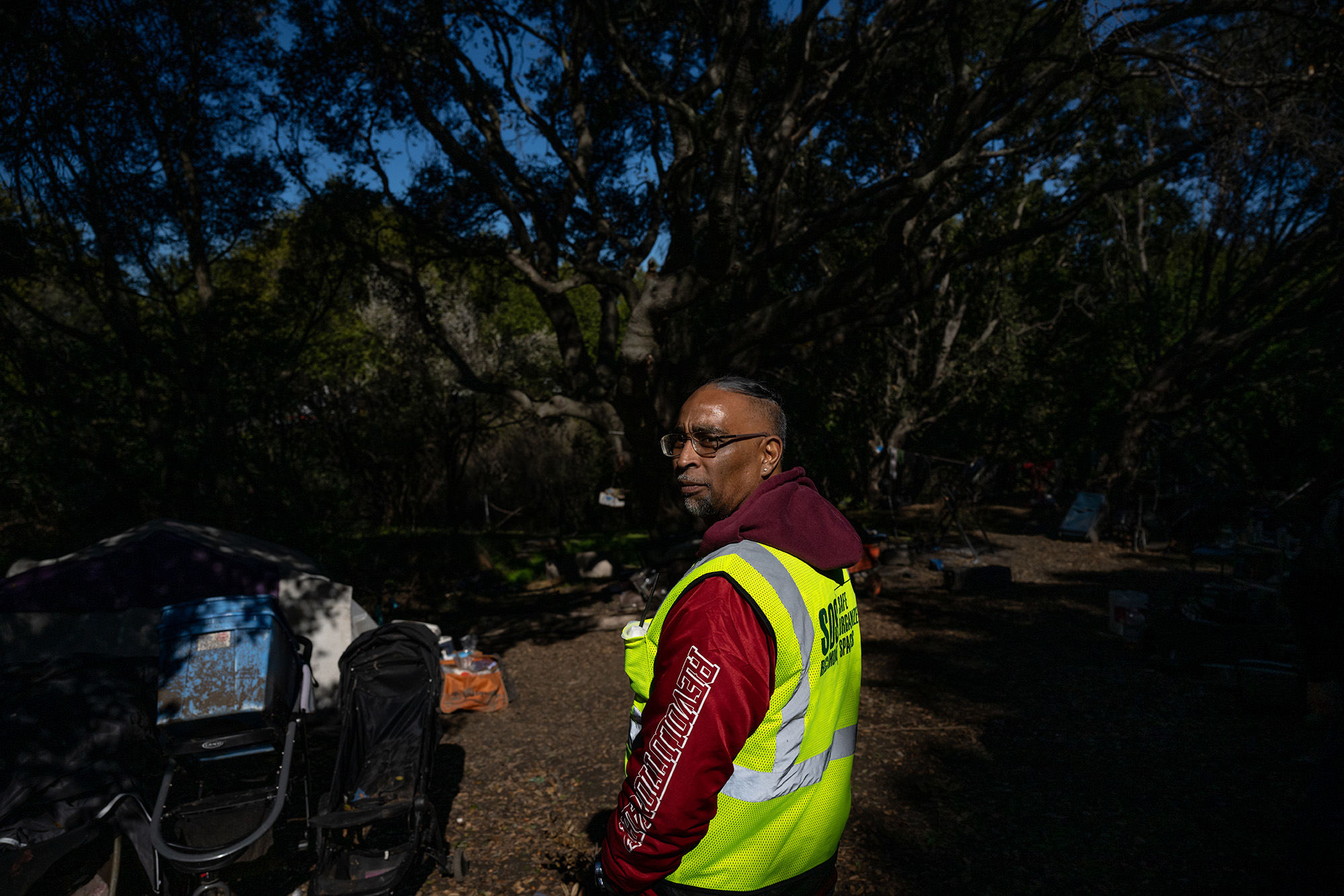 Man in a yellow vest, turning to look at the camera.