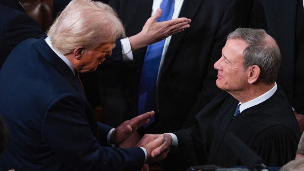 Trump, in a blue suit, shakes hand with Chief Justice Roberts, in a black robe.