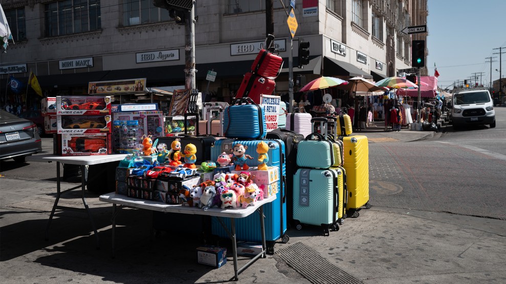 A vendor's merchandise table sits at a city intersection with no people in sight.