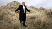 Donald Trump standing on sand dunes.