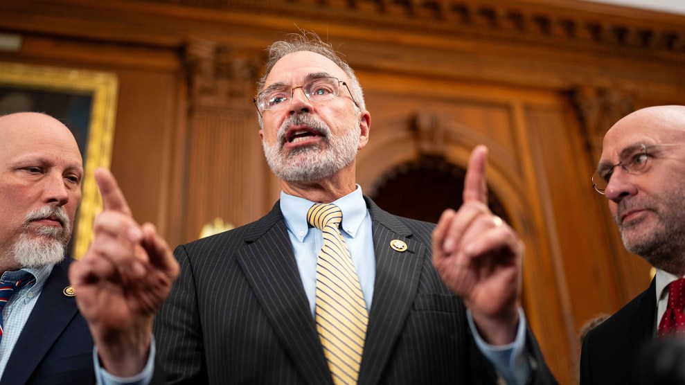 Three white men speak in while wearing suits.