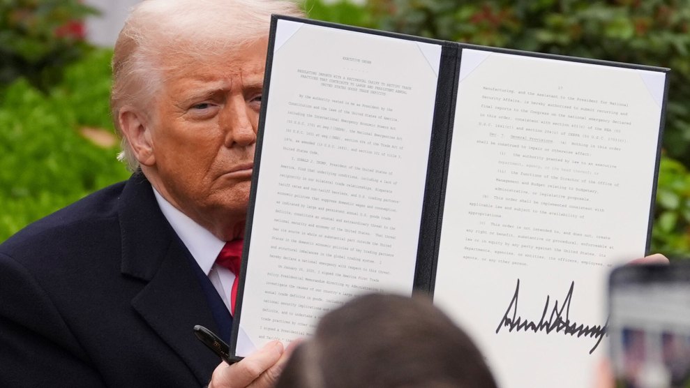 President Donald Trump holds up a recently signed executive order.