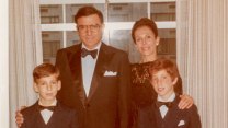 A 1970s-era snapshot of a white family of four with father and two suns wearing matching tuxedos with bow ties and white pocket squares. The woman is wearing a dark dress. Only the dad seems to be smiling authentically.