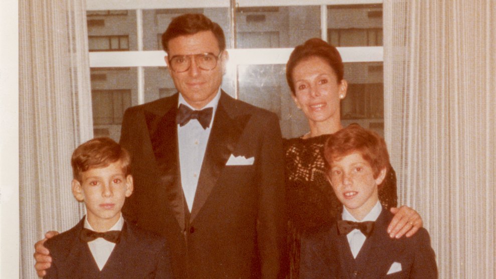 A 1970s-era snapshot of a white family of four with father and two suns wearing matching tuxedos with bow ties and white pocket squares. The woman is wearing a dark dress. Only the dad seems to be smiling authentically.