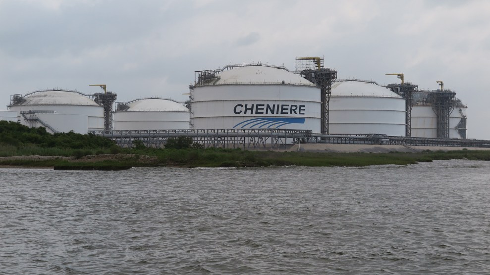 Several white cylindrical buildings by the water with the name "Cheniere" on them.