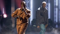 Rap duo Clipse perform on stage during the BET Hip Hop Awards in 2022. Pusha T is in front wearing a light brown jacket and light brown pants, and Malice is in the back in a black jacket and blue pants.