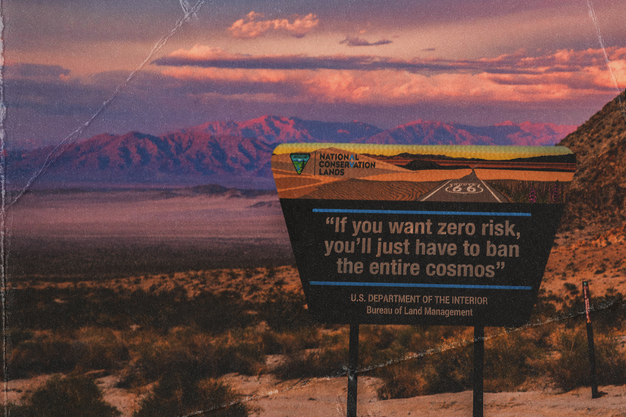 A desert with a sign that says "If you want zero risk, you just have to ban the entire cosmos."