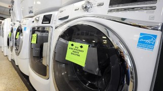 A row of several front-load washing machines, the closest one features a blue "energy star" label.